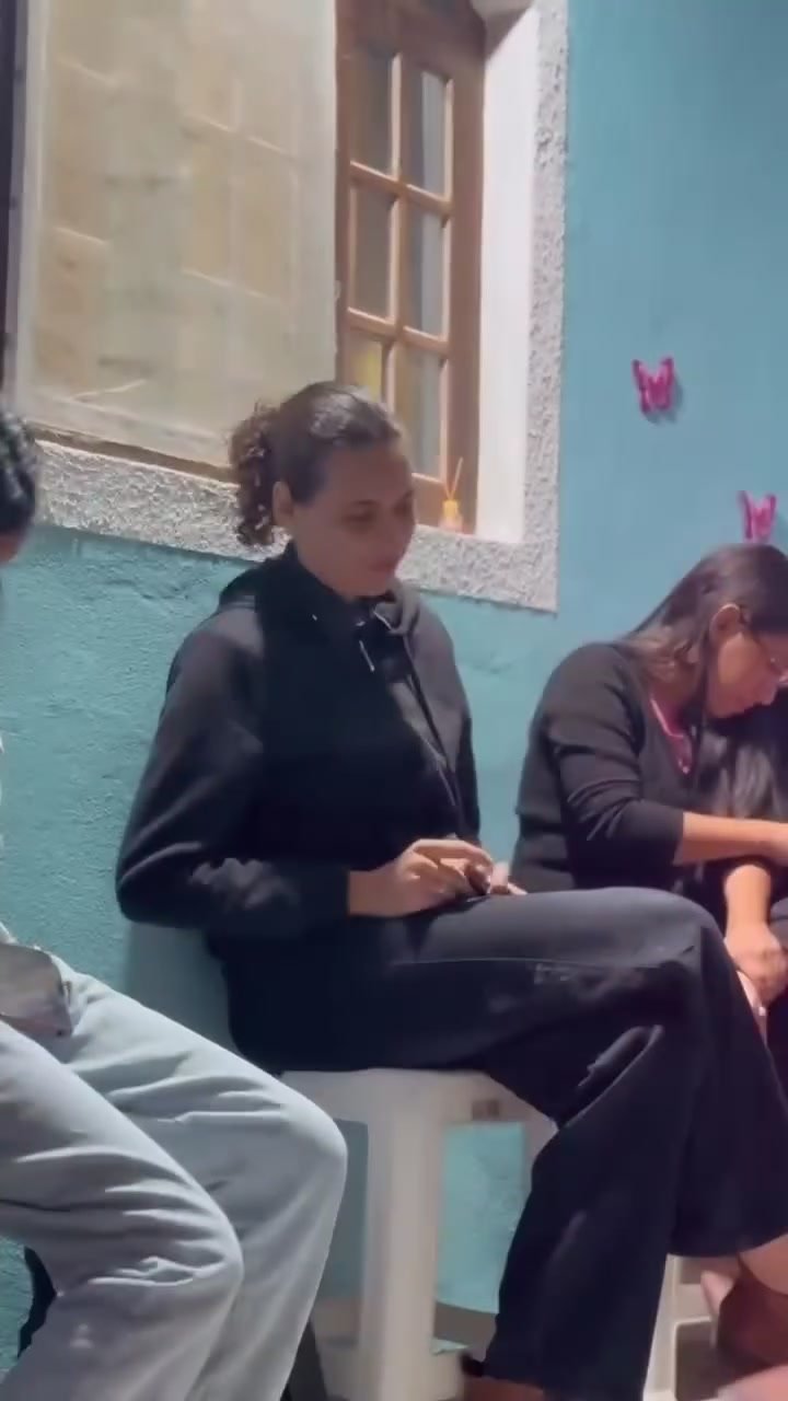 Duas mulheres se abraçando sob luz rosa